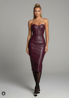 Woman wearing a strapless burgundy leather dress on a gray background