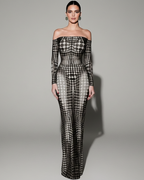 Woman wearing a black and white patterned off-shoulder gown on a gray background
