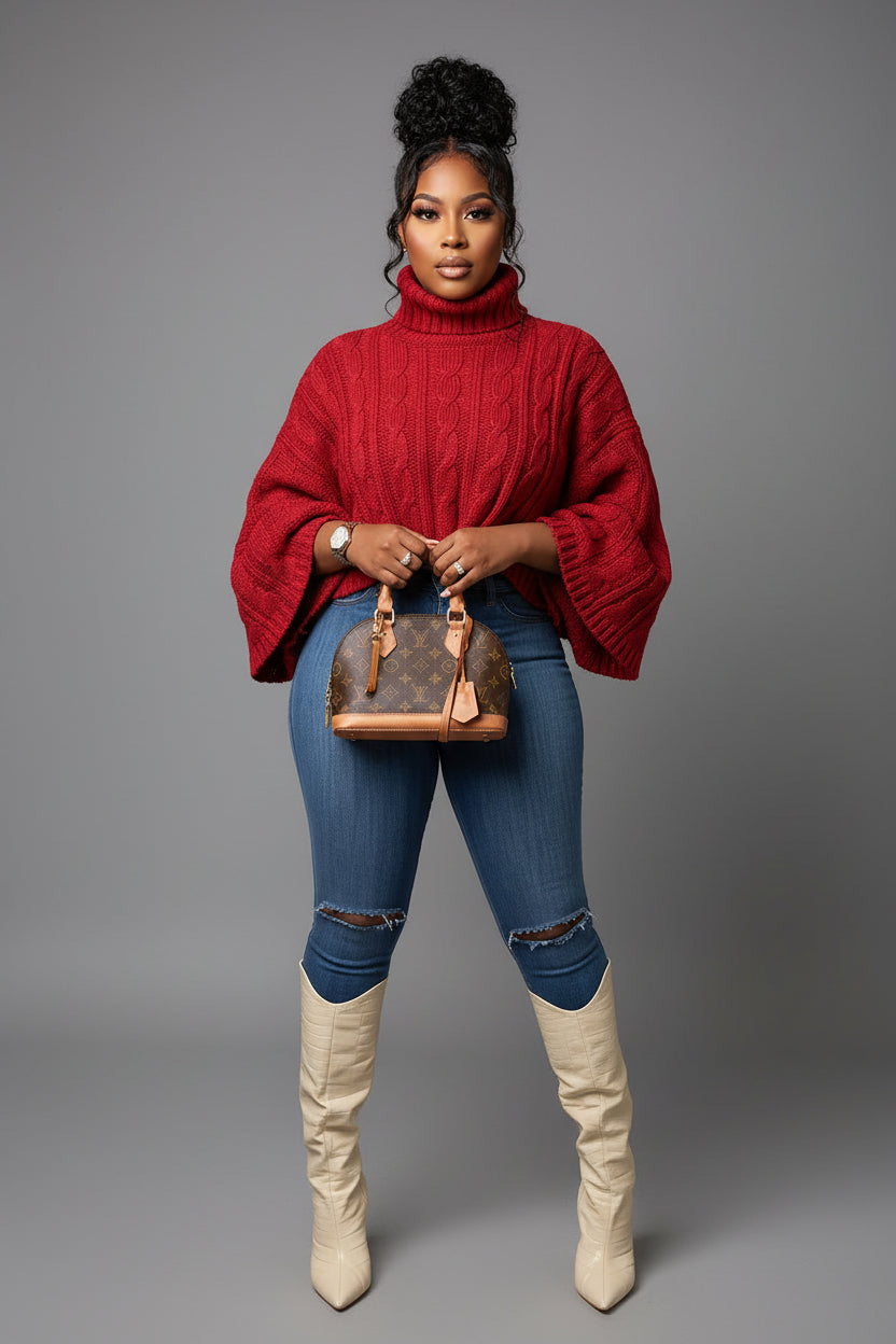 Person wearing a red sweater, blue jeans, and white boots taking a mirror selfie.