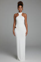 Woman in a white dress standing in a modern living room.